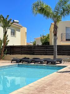 普罗塔拉斯Casa Pernera的一个带椅子的游泳池,并种植了棕榈树