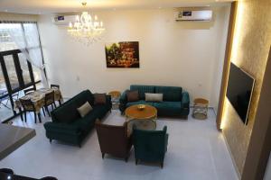 QurayyahAYLOL-أيلول的客厅配有绿色家具和吊灯。