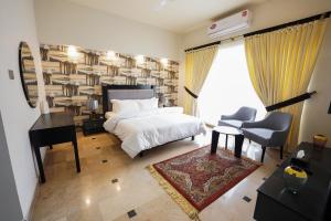伊斯兰堡SK Residence的一间卧室配有一张床、一张书桌和一个书架