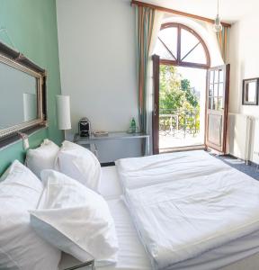 GrafeneggMÖRWALD Grafenegg Hotel的卧室配有一张大白色床和窗户