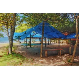 帕拉蒂Cabana Caiçara Praia do Sono Paraty RJ的海滩上的蓝色帐篷,配有野餐桌