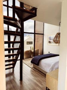 ShigarKhoj Resorts的一间卧室设有高架床和螺旋楼梯。