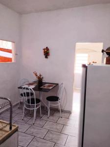 尤西德福拉Hospedagem Progresso的厨房配有桌椅和冰箱。