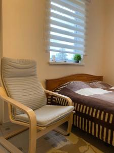 林巴日SweetHome的卧室配有床、椅子和窗户。