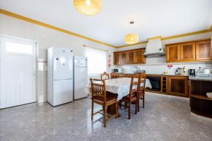 萨格里什Local Guesthouse的厨房配有桌子和白色冰箱。