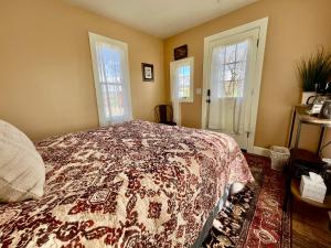 PaoniaViolet Cottage at Zenzen Gardens的一间卧室配有一张带鲜花毯子的床