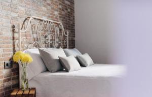 阿索马达Casa Serendipia的卧室配有白色的砖墙床
