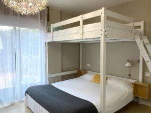 巴约讷sabaris -BAIONA a 200 metros de Playa Ladeira的一间卧室配有一张双层床和吊灯。