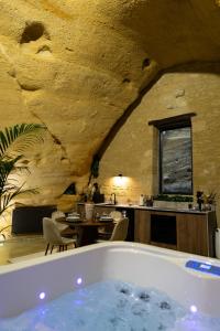 杜埃拉丰坦La falaise perdue : Suite troglodyte grandiose的带浴缸和桌子的客房以及厨房