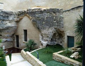 杜埃拉丰坦La falaise perdue : Suite troglodyte grandiose的石头建筑,有岩石墙和一些植物