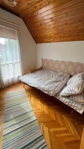 鲍洛通凯赖斯图尔Vitorlás Haus的一张位于带木制天花板的客房内的大床