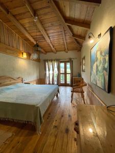 康格拉Osho Himalayas Wellness Resort的一间卧室设有一张大床,铺有木地板