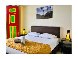 萨兰托HOTEL SHAMBALA的卧室里设有一张床,上面有一只动物