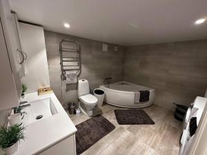 奥勒松Basement apartment with parking的带浴缸、卫生间和盥洗盆的浴室
