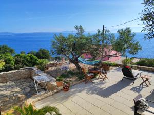 Donje Selo na ŠoltiWeekend house Olive garden的一个带椅子和吊床的庭院和大海