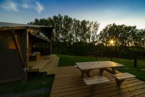 MortierLe Relais d'Artagnan - relais équestre的木甲板上设有野餐桌和凉亭