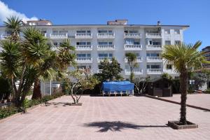 布拉内斯Alegre apto con piscina, a 300m de la playa.的一座白色的大建筑,前面有棕榈树