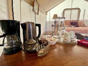 PaoniaZinnia Glamping Tent at Zenzen Gardens的一张桌子,上面有咖啡壶和其他物品