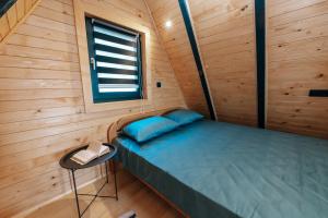 利夫诺Lake House Beliz的小木屋内的一张小床,设有窗户