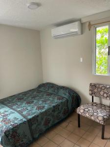 博卡德尔里奥Departamento centro de Boca del Río的卧室配有床、椅子和窗户。