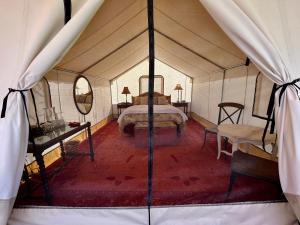 PaoniaCosmo Glamping Tent at Zenzen Gardens的帐篷内的一个床位房间