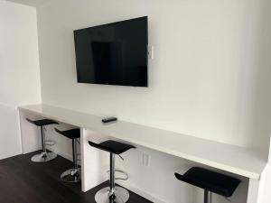 迈阿密**New** Cozy and Detailed Brickell Studio的一张带凳子的白色书桌和墙上的电视