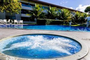 塔曼达雷Flat Beira Mar - Carneiros Beach Resort的大楼前方的蓝色海水大型游泳池