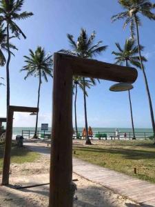 塔曼达雷Flat Beira Mar - Carneiros Beach Resort的棕榈树海滩上的木标志