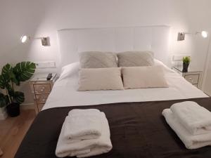 埃尔切Lujoso y acogedor apartamento "súper céntrico" en ELche的卧室配有一张白色大床和两条毛巾
