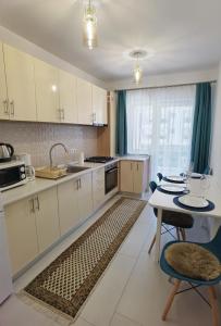 锡比乌Select Apartment SIBIU的厨房配有白色橱柜和桌椅