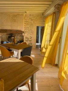 BessinesLogis de Pierre Levée的用餐室配有木桌和黄色窗帘
