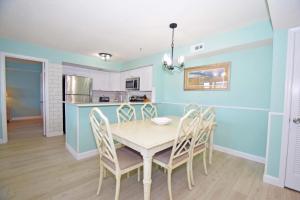 大洋城Seascape-Heron Harbour 200-9的厨房以及带桌椅的用餐室。