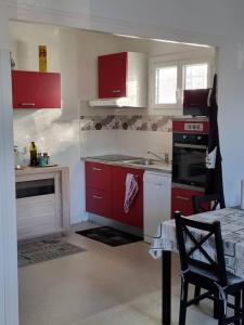 索容Port de Riberou的厨房配有红色橱柜和桌椅