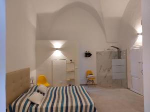 塔维亚诺Corte Petricore的一间卧室配有一张床和两张黄色椅子