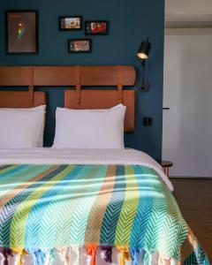 恰纳卡莱The Abies的一间卧室配有一张带彩色毯子的床