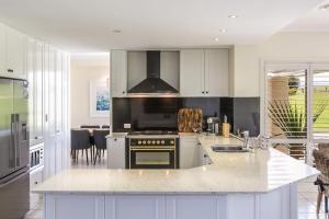 贝利Cullengetty Estate的厨房配有白色橱柜和炉灶烤箱。