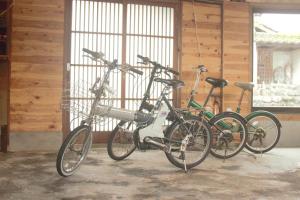 阿苏市阿蘇び心 Asobi Gokoro的两辆自行车停放在车库里,彼此相邻