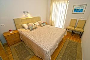 杜布罗夫尼克Apartment Duby的一间卧室配有一张大床和两把椅子