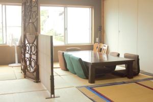 阿苏市阿蘇び心 Asobi Gokoro的一间带木桌和椅子的用餐室