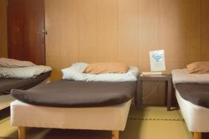 阿苏市阿蘇び心 Asobi Gokoro的客房设有两张床和一张带标志的桌子。