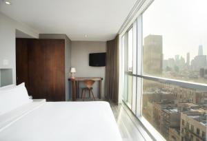 纽约利文顿酒店的酒店客房设有一张床和一个大窗户