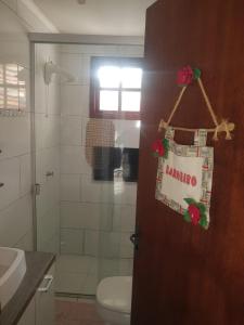 圣玛丽亚Conforto e comodidade em Santa Maria的一间带卫生间的浴室和一扇门,门上标有标志
