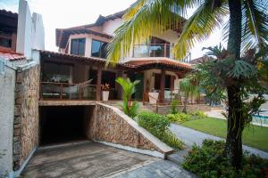 尼泰罗伊Casa a 50m da Praia de Itacoatiara Niteroi RJ的前面有棕榈树的房子