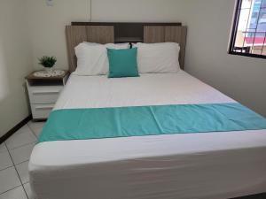 伊塔佩马Apartamento vista mar com 3 quartos e churrasqueira的一间卧室配有一张带蓝白色枕头的大床