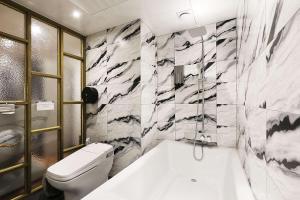 平泽市Mariposa Hotel Songtan的浴室配有白色浴缸和卫生间。