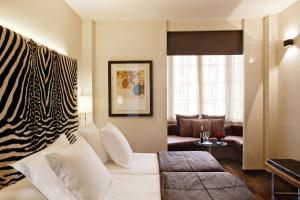 巴塞罗那Hotel Gran Derby Suites, a Small Luxury Hotel of the World的客厅配有白色沙发和斑马毯