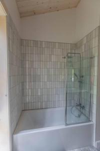 圣多纳特蒙卡尔姆Le Boréal的浴室设有带玻璃淋浴的浴缸