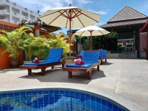 卡塔海滩Kata Silver Sand的一组椅子和遮阳伞,位于游泳池旁