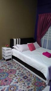 ChemorCASA Singgah Homestay的一间卧室配有带白色床单和红色枕头的床。