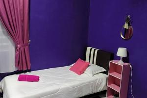 ChemorCASA Singgah Homestay的紫色卧室配有一张带两个粉红色枕头的床